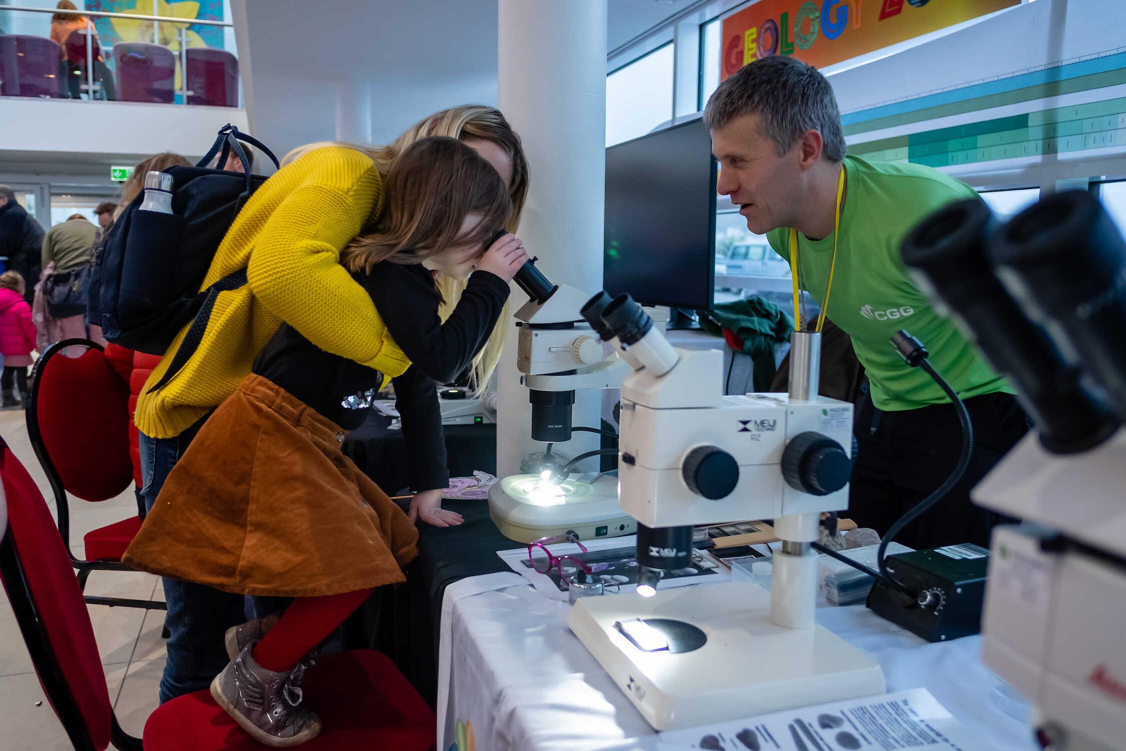 child looking in to microscope