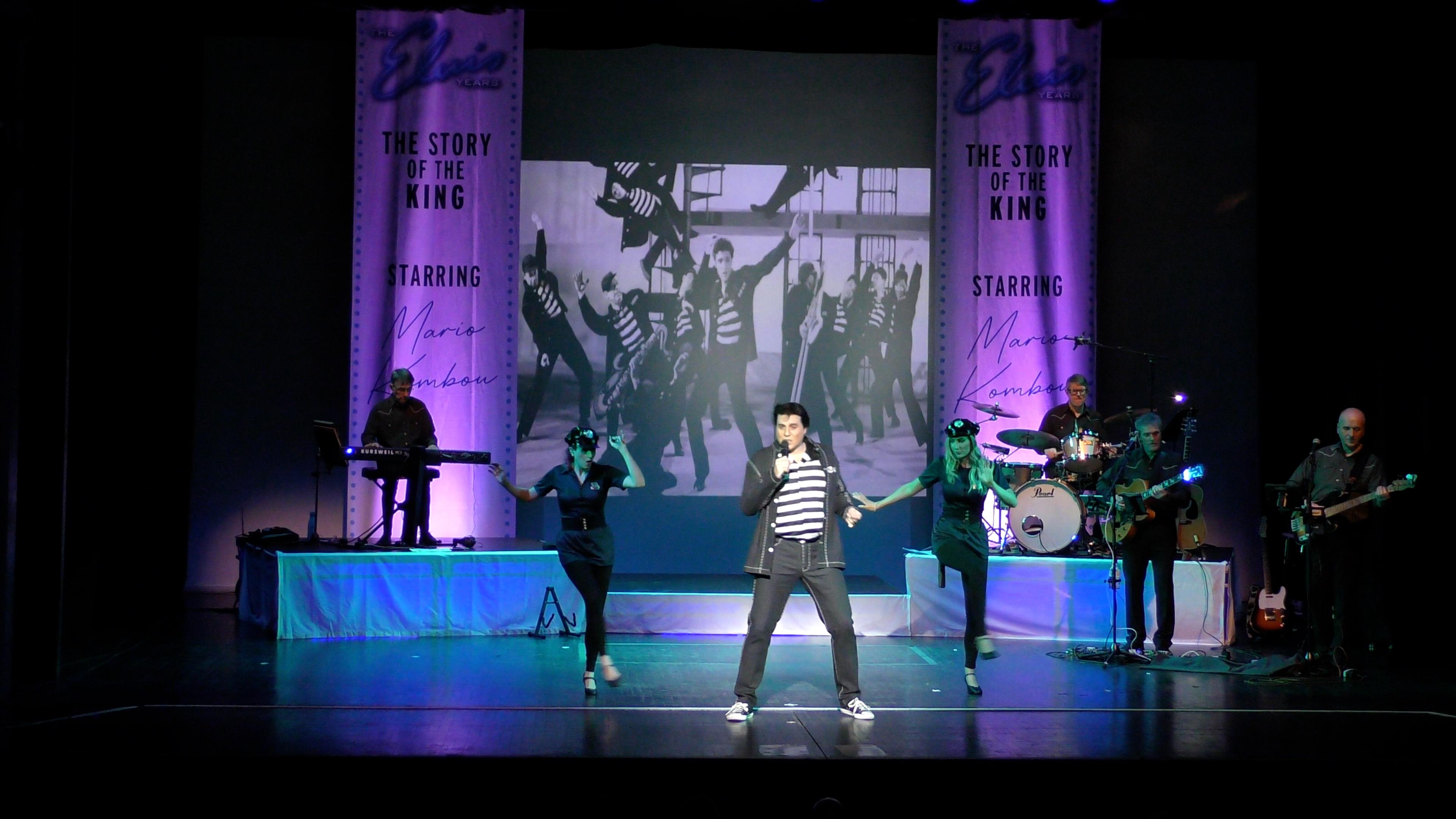 Man singing on stage in a stripy shirt