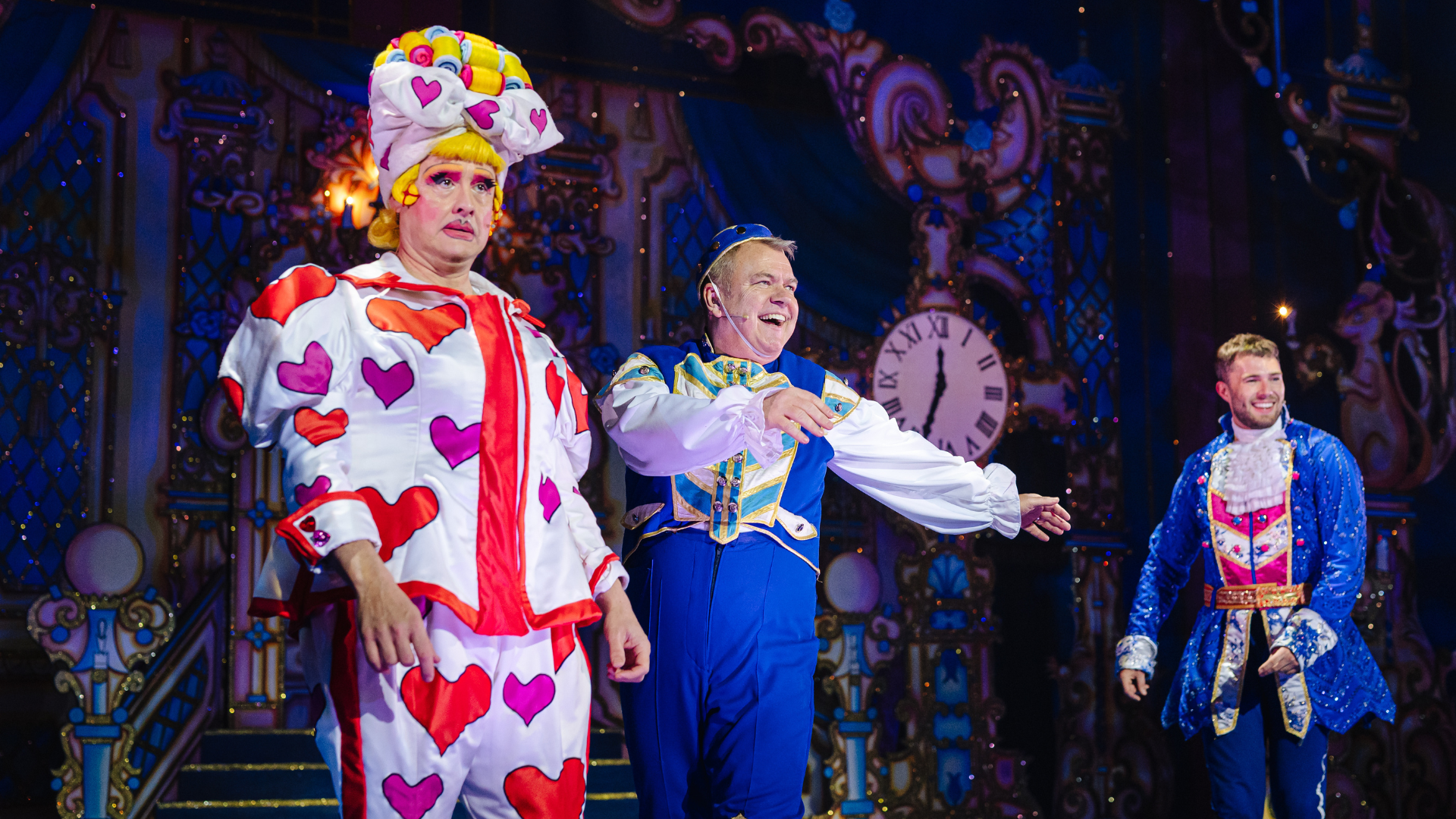 Three people on the stage with one pointing