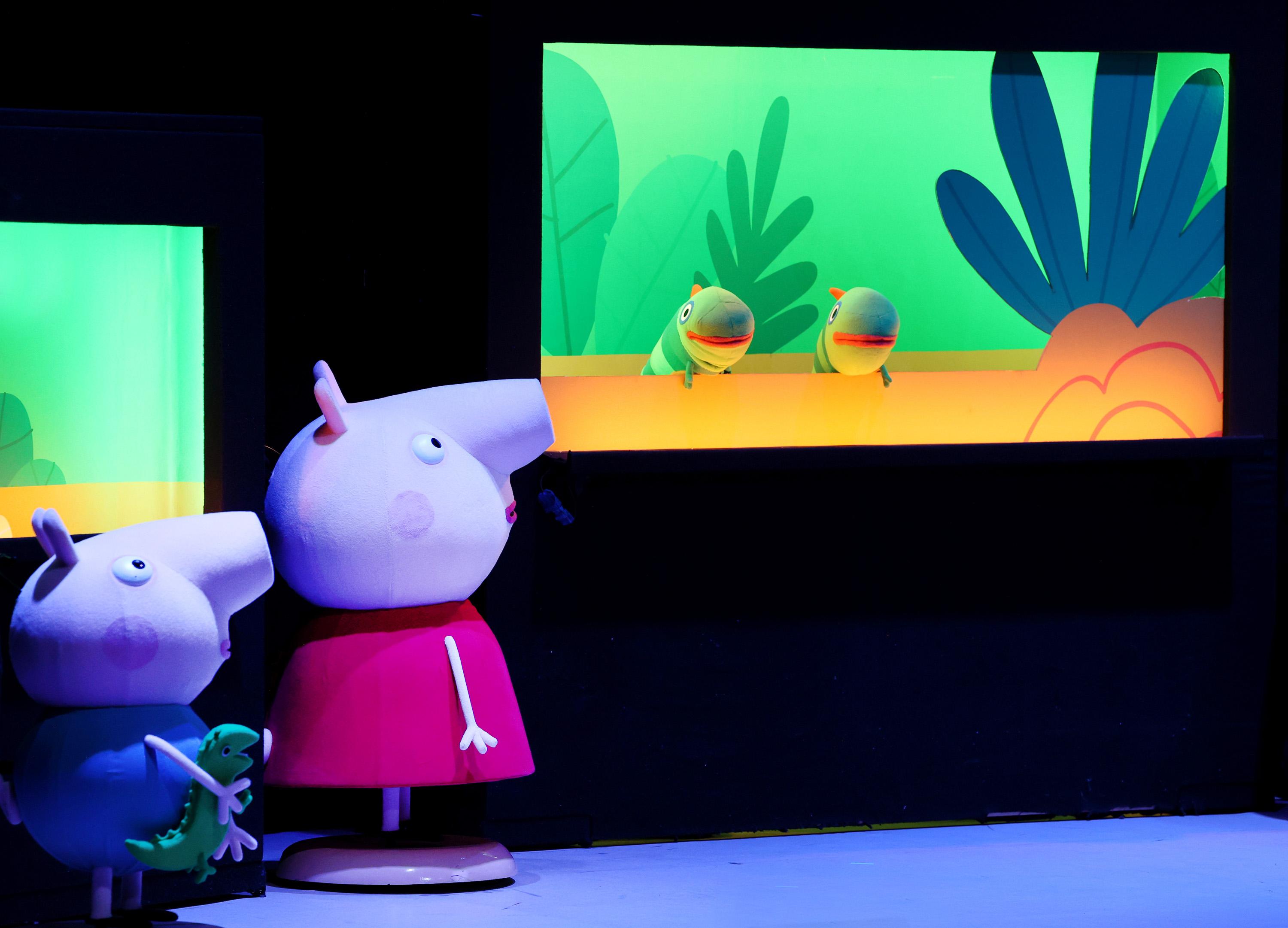 two pig puppets looking at an aquarium