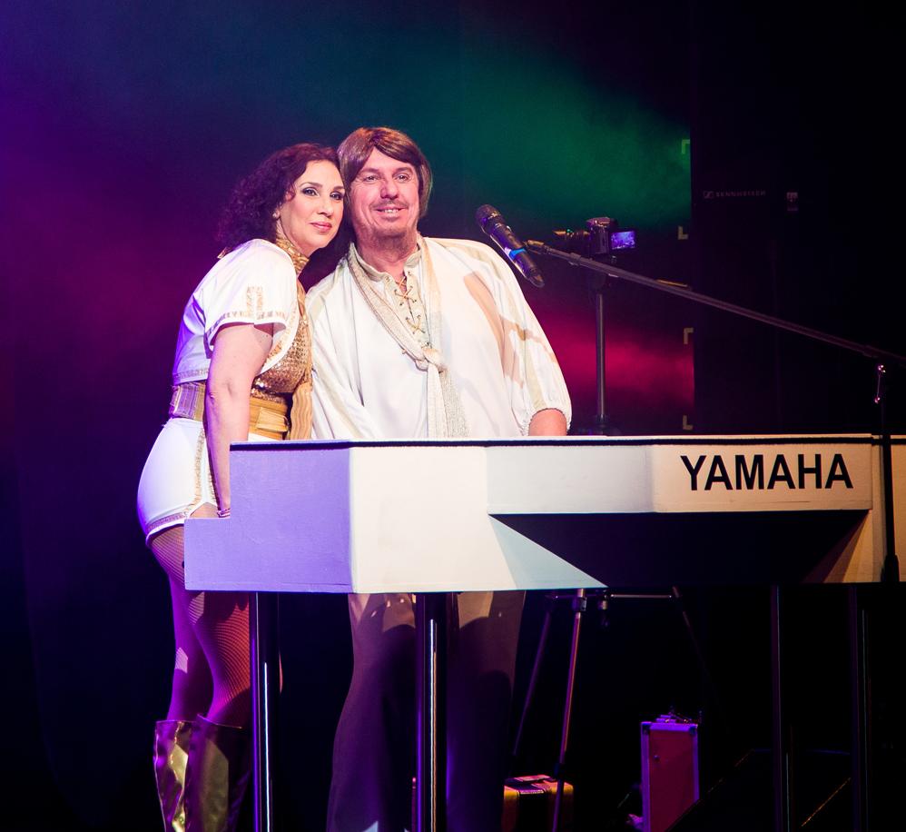 Two singers around a Yamaha Piano 