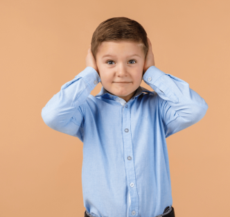 child with hands over ears