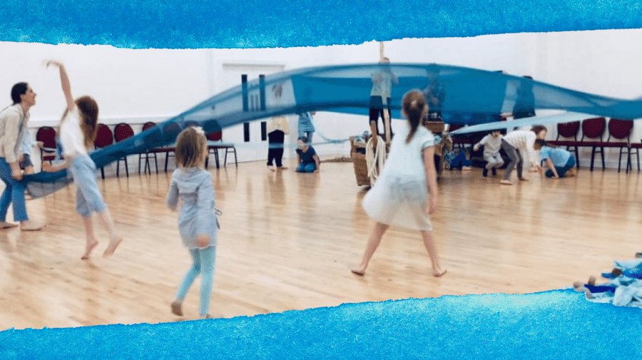 image of children dancing with material