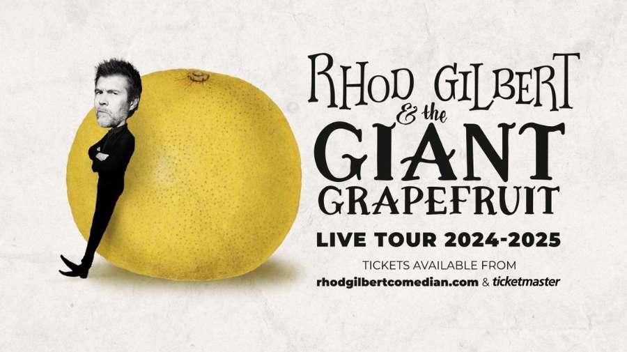 Rhod Gilbert leaning against a giant grapefruit