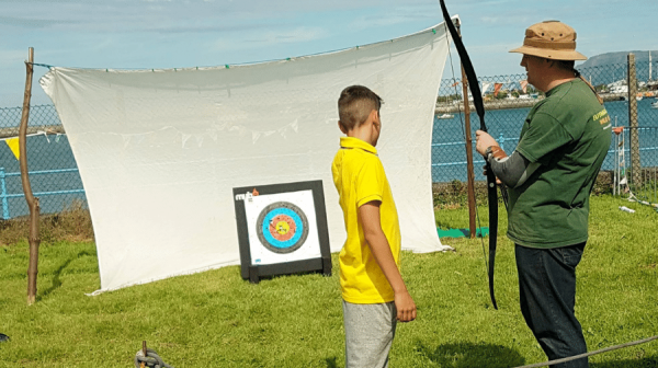 image of person showing child how to use an arrow