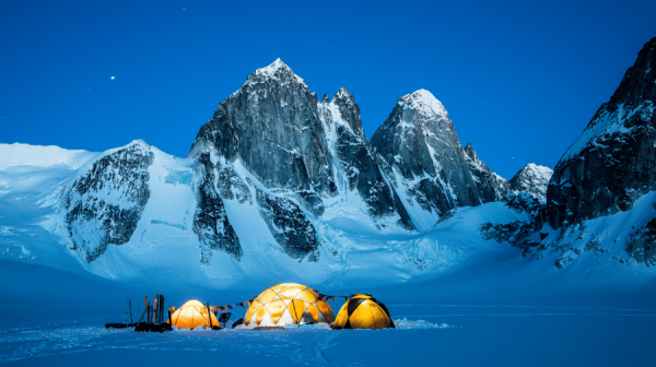 image of campers at the foot of a mountain