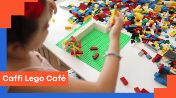 a child playing with a table of lego and the words caffi lego cafe in the left hand corner, on an orange background 