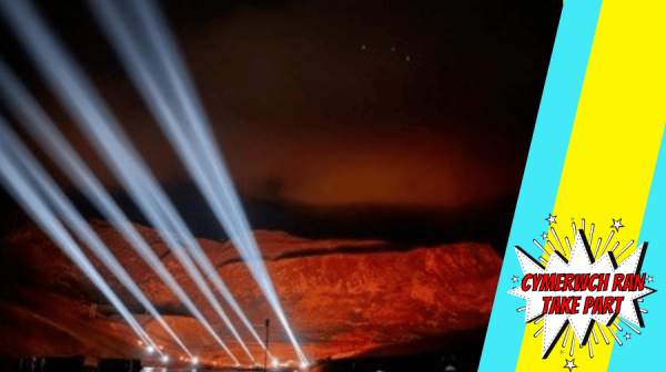 a photo of Uluru with lights beaming out from it, at night 