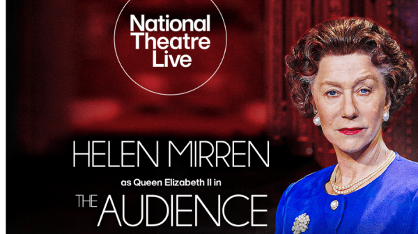 A woman imitating Queen Elizabeth The Second, wearing a royal blue top with curly, short, dark hair.